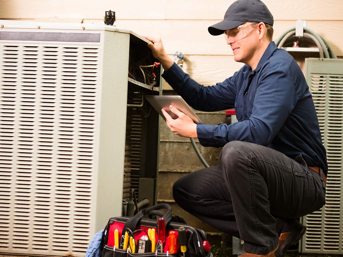 man repairing an ac unit